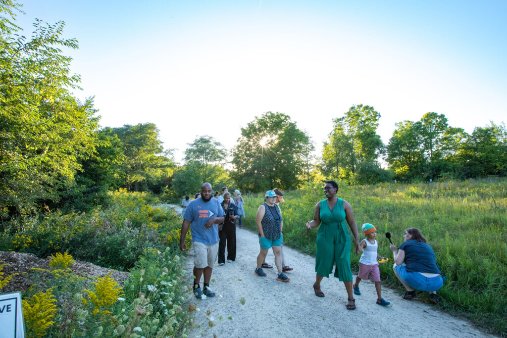 Qwantese Dourese Winters (right, in green) kicked off her 2023 residency with a tour of Troy Farm on Sept. 1, 2023. Attendees learned more about her journey and discovered this urban working farm.