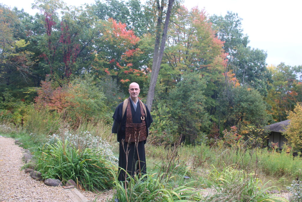 Meido Moore walks through greenery of Madison's Korinji monastery. The Korinji trails experiences the touches of fall as the once green trees move into shades of oranges.