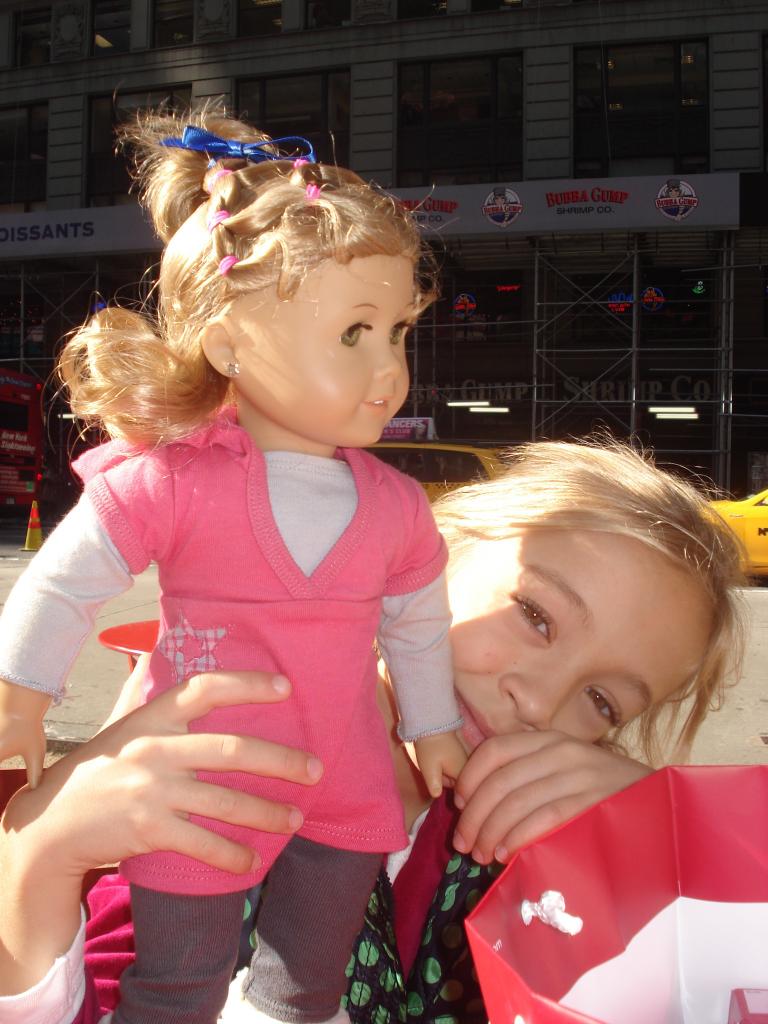 Beaming with glee, Ava Wojnowski hold my American Girl doll up for a photo after she got her hair done and ears pierced in Chicago. Katie was a look alike doll and Ava loved having a doll version of herself.