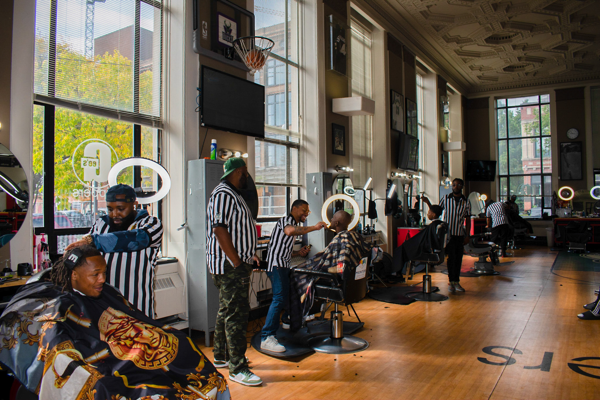 A group of barbers were cutting hairs for customers at their space